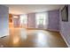 Open concept living room with hardwood floors, bright natural light, and neutral purple paint at 1325 Countryside Ln, Indianapolis, IN 46231