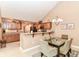 Open floor plan showcases kitchen with wood cabinetry and dining room with glass-top table at 13807 Rue Fontaine Ln, McCordsville, IN 46055