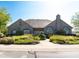 Stone Clubhouse boasts lush landscaping, including a variety of colorful flowers and green bushes at 13807 Rue Fontaine Ln, McCordsville, IN 46055