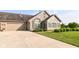 Charming stone house featuring a well-maintained lawn, a two-car garage and meticulously kept front yard landscaping at 13807 Rue Fontaine Ln, McCordsville, IN 46055