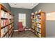 Cozy library with floor-to-ceiling bookshelves, a comfortable chair, and a window for natural light at 13807 Rue Fontaine Ln, McCordsville, IN 46055