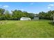 Expansive backyard featuring a white barn, a well-maintained lawn, and surrounded by lush greenery and fencing at 1382 S Morgantown Rd, Greenwood, IN 46143