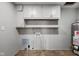 Functional basement with storage cabinets, utility connections, and water heater at 1382 S Morgantown Rd, Greenwood, IN 46143