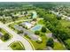 Aerial view showcasing a community pool, tennis court, playground, and scenic pond in a neighborhood setting at 13861 Barberry Ct, Carmel, IN 46033