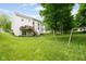 Spacious backyard with lush green lawn, mature trees, a deck with stairs, and a swing set at 13861 Barberry Ct, Carmel, IN 46033