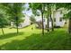 Backyard showing the exterior of the home, mature trees, a hammock, and a swing set at 13861 Barberry Ct, Carmel, IN 46033