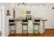 Entertaining basement with a tiled bar, wooden countertop, three stools, and decorative lighting above at 13861 Barberry Ct, Carmel, IN 46033
