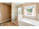 Bright bathroom featuring a glass-enclosed shower and a large soaking tub beneath a window at 13861 Barberry Ct, Carmel, IN 46033
