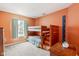 bedroom with a wooden bunk bed and bright orange walls, creating a fun space at 13861 Barberry Ct, Carmel, IN 46033