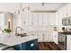 Modern kitchen featuring white cabinets, a stylish island with seating, stainless steel appliances, and elegant light fixtures at 13861 Barberry Ct, Carmel, IN 46033
