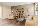 Cozy living room featuring hardwood floors, earth-toned walls, and a custom bookshelf display at 13861 Barberry Ct, Carmel, IN 46033