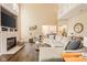 Bright, open living room with a fireplace, high ceilings, and views into the kitchen at 13861 Barberry Ct, Carmel, IN 46033