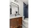 Bathroom features an elegant vanity, mirror, and dark blue tiled shower/tub at 1405 Deloss St, Indianapolis, IN 46201