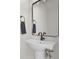 Charming powder room featuring a pedestal sink, a modern black faucet and light fixture, and a framed mirror at 1405 Deloss St, Indianapolis, IN 46201