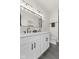 Modern bathroom featuring double sinks, a large mirror, and dark tile flooring at 1405 Deloss St, Indianapolis, IN 46201