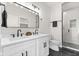 Bright bathroom with double sinks, a large mirror, and tiled shower with glass door at 1405 Deloss St, Indianapolis, IN 46201