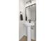 Charming powder room featuring a pedestal sink, a modern black faucet and light fixture, and a framed mirror at 1405 Deloss St, Indianapolis, IN 46201