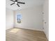 Bright bedroom with light wood flooring, white walls, ceiling fan, and large window at 1405 Deloss St, Indianapolis, IN 46201