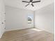 A clean white bedroom with light colored floors, window, and a simple ceiling fan at 1405 Deloss St, Indianapolis, IN 46201