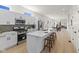 Open kitchen with white cabinets, stainless steel appliances, an island with seating, and a view of the living and dining area at 1405 Deloss St, Indianapolis, IN 46201