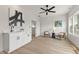 Stylish living space with a wet bar, modern ceiling fan, light wood floors, and neutral paint tones at 1405 Deloss St, Indianapolis, IN 46201