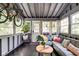Cozy sunroom with exposed ceiling beams, wraparound windows, and comfortable seating area at 1548 N Park Ave, Indianapolis, IN 46202