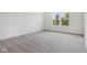 A spacious bedroom features a window offering natural light and neutral carpet at 1669 Windrush Pl, Westfield, IN 46074