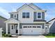 Two-story home boasts a white garage door, stylish gray siding, and a welcoming front porch at 1669 Windrush Pl, Westfield, IN 46074