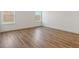 Bright bedroom with wood-look flooring, natural light from the windows, and neutral walls. Perfect for relaxation and comfort at 1694 Windrush Pl, Westfield, IN 46074