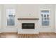 Modern fireplace with a wooden mantel, complemented by natural light from adjacent windows and hardwood floors at 1694 Windrush Pl, Westfield, IN 46074