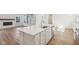 Kitchen island with stainless steel dishwasher, sink, white cabinets and an open concept to the living area at 1694 Windrush Pl, Westfield, IN 46074