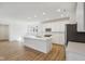 Bright, open kitchen featuring a large island, white cabinets, and stainless steel appliances at 1694 Windrush Pl, Westfield, IN 46074