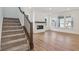 Inviting living room featuring a fireplace, large windows, hardwood floors, and staircase access at 1694 Windrush Pl, Westfield, IN 46074