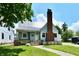 Charming home with a metal roof, brick chimney, and a well-maintained lawn on a sunny day at 209 E John St, Alexandria, IN 46001