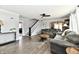 Spacious living room with hardwood floors, grey sofas, a staircase, and an archway leading to the dining room at 209 E John St, Alexandria, IN 46001