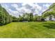 Lush backyard with green lawn, mature trees, trampoline, and stone patio at 2096 Whitetail Ct, Avon, IN 46123