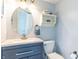 Cozy bathroom showcasing a gray vanity, round mirror, and shelving at 2096 Whitetail Ct, Avon, IN 46123