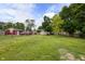 Expansive backyard featuring lush green grass, mature trees, and a detached garage at 2164 E Raymond St, Indianapolis, IN 46203