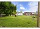 A spacious backyard with two buildings, lush grass and mature trees on a sunny day at 2164 E Raymond St, Indianapolis, IN 46203