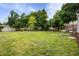 Grassy backyard with mature trees and a small shed at 2164 E Raymond St, Indianapolis, IN 46203