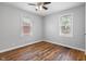 Sunlit bedroom featuring hardwood floors, a ceiling fan, and a large window at 2164 E Raymond St, Indianapolis, IN 46203