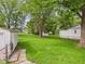 Expansive backyard with lush green grass, mature trees, and storage sheds, perfect for outdoor activities and storage at 2405 E 9Th St, Anderson, IN 46012