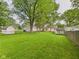 A sprawling backyard with well-maintained lawn, mature shade trees, and convenient outbuildings and storage at 2405 E 9Th St, Anderson, IN 46012