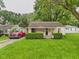 Traditional home with a cozy front porch, neat landscaping, and gravel driveway at 2405 E 9Th St, Anderson, IN 46012