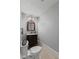 Bathroom with a dark vanity cabinet and a marble countertop beneath a decorative mirror and sconce lighting at 245 S Washington St, Danville, IN 46122