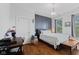 Comfortable bedroom featuring hardwood floors, a stylish accent wall, and large windows at 245 S Washington St, Danville, IN 46122