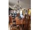 Elegant dining room with a classic chandelier, wooden table, and views into the living room at 247 Meridian Ct, Pittsboro, IN 46167