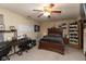 Spacious bedroom with ceiling fan, plush carpet, desk, and a large bed with dark wood frame at 2782 Branigin Creek Blvd, Franklin, IN 46131