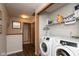 Bright laundry area with modern appliances, storage shelves, and hardwood floors at 2782 Branigin Creek Blvd, Franklin, IN 46131