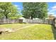 Well-maintained backyard with grassy lawn, mature trees, and a wooden fence surrounding the property at 31 S Hinman St, Columbus, IN 47201
